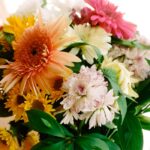 Beautiful close-up of a colorful and vibrant bouquet featuring various flowers with lush green leaves.