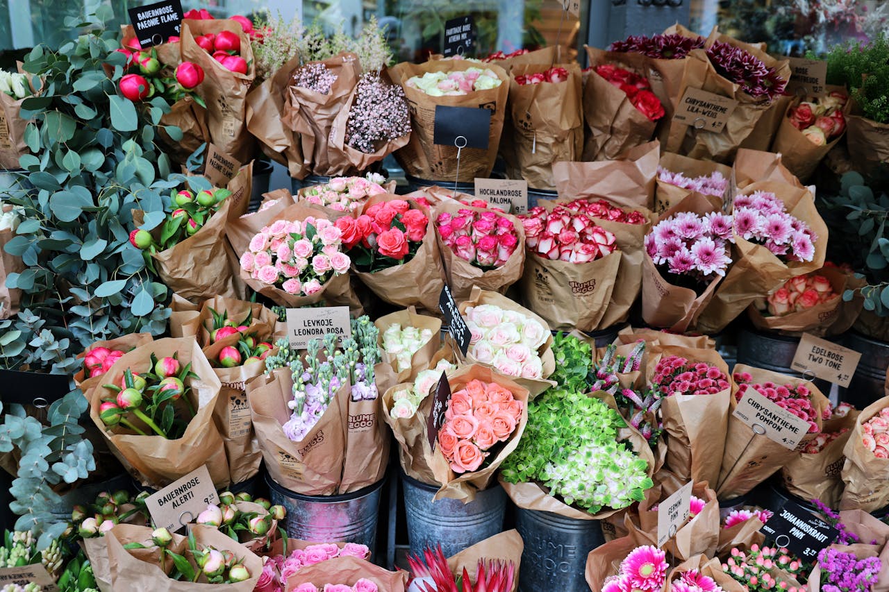 hero-img-01 Colorful floral bouquets arranged in a busy outdoor market showcasing a variety of fresh blooms.