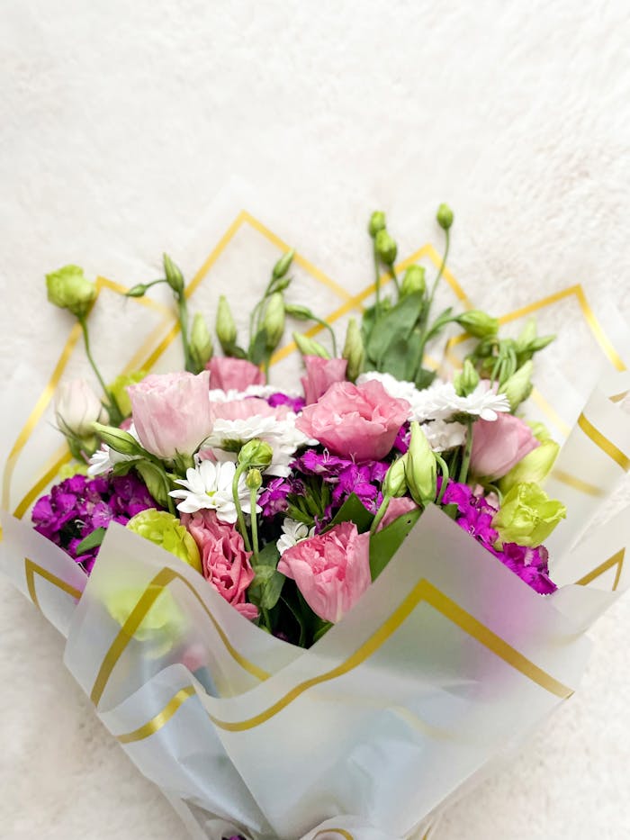 A vibrant bouquet of mixed flowers showcasing greens, pinks, purples, and whites.