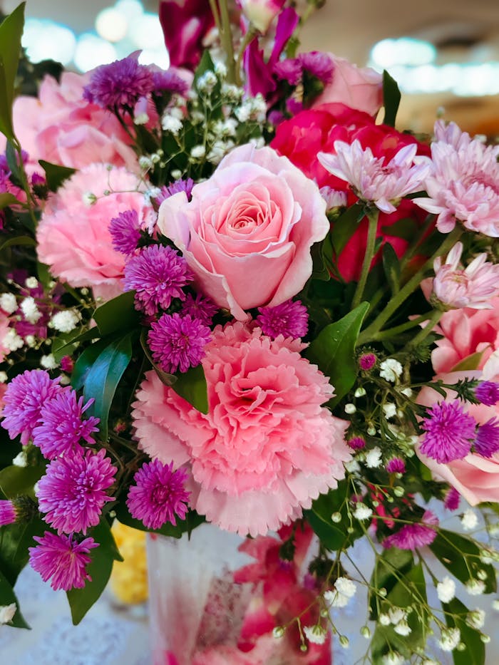 A beautiful bouquet of pink roses, carnations, and chrysanthemums in a vase.