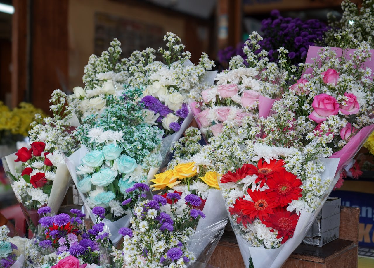 hero-img-02 Colorful flower bouquets displayed in a floral shop with roses and daisies.